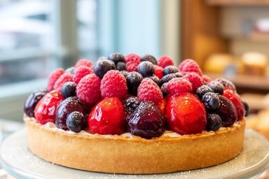 Fruit tart with glossy berries displayed in a bakery window